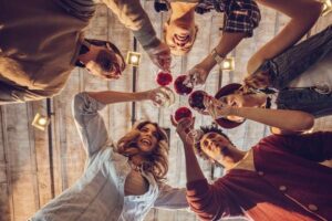 Low angle view of happy young colleagues working in a start up team toasting to their success.