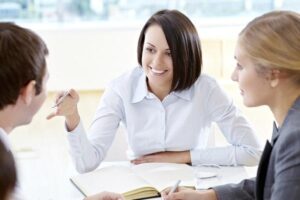 Three women working in a secretarial agency having a meeting and talking.