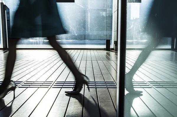A shot of a woman wearing high heels in the workplace while walking around outside.