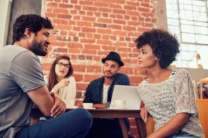 A PA talking to colleagues in a modern, open plan office.