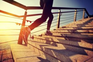 A woman’s legs as she’s running up stairs on her morning jog.