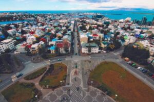 An overhead shot of Iceland’s city centre, near the coast with the sea in the background and colourful houses.