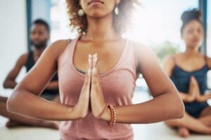 A yoga wellbeing specialist in a yoga pose while leading a class.