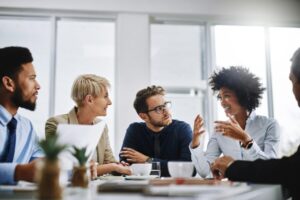 A group of managers sitting around a desk, discussing how employee engagement is shifting in 2019.