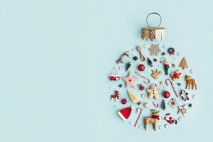 A Christmas ornament made up of tiny little symbols of Christmas, including a santa hat, candy canes, and Christmas trees.