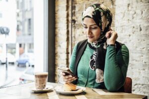 Mid adult woman using smartphone in cafe