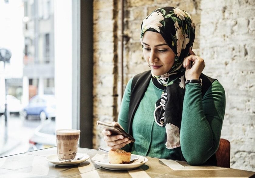 Mid adult woman using smartphone in cafe