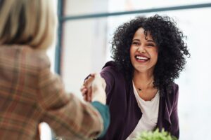 Receptionist smiles in her interview and shakes hands with her interviewer