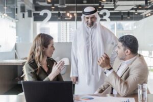 A group of three human resources professionals discussing business strategy and decisions in modern office in the Middle East.