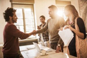 Happy man is shaking hands with mid adult businessman.