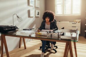 Woman working on new building plans while sitting at her desk.