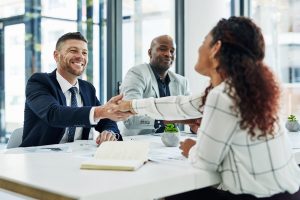 Two businessmen congratulating a successful job interviewee