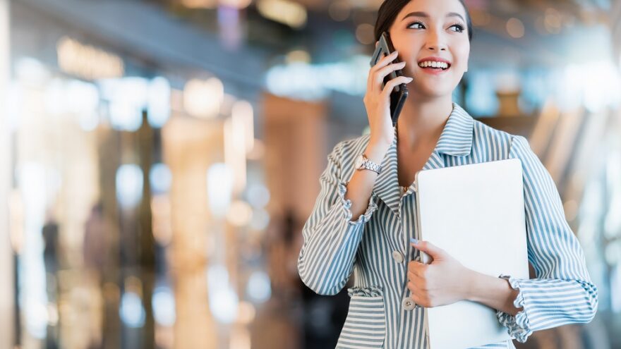 A businesswoman on the phone in a bright, modern office.