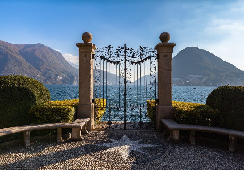 Gates of a large house leading onto a lake