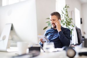 An assistant taking a phone call in a modern office.