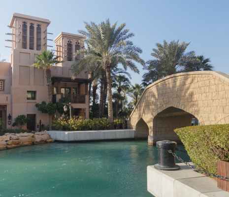 Exterior of a large dubai house with a bridge crossing a moat.