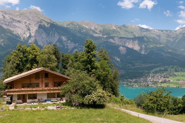 A mountain chalet overlooking a Swiss lake on a sunny day.