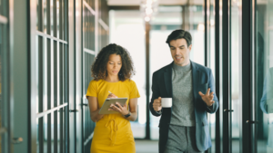Man and woman walking together in office in discussion