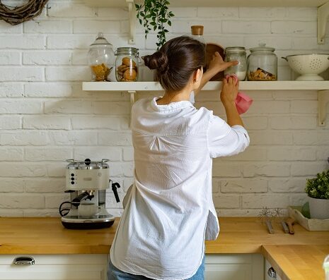 Young woman cleaning dust at the kitchen
