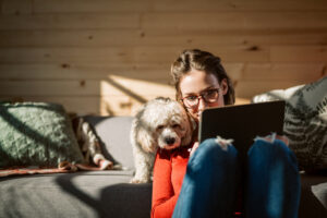 Woman with dog working on a laptop
