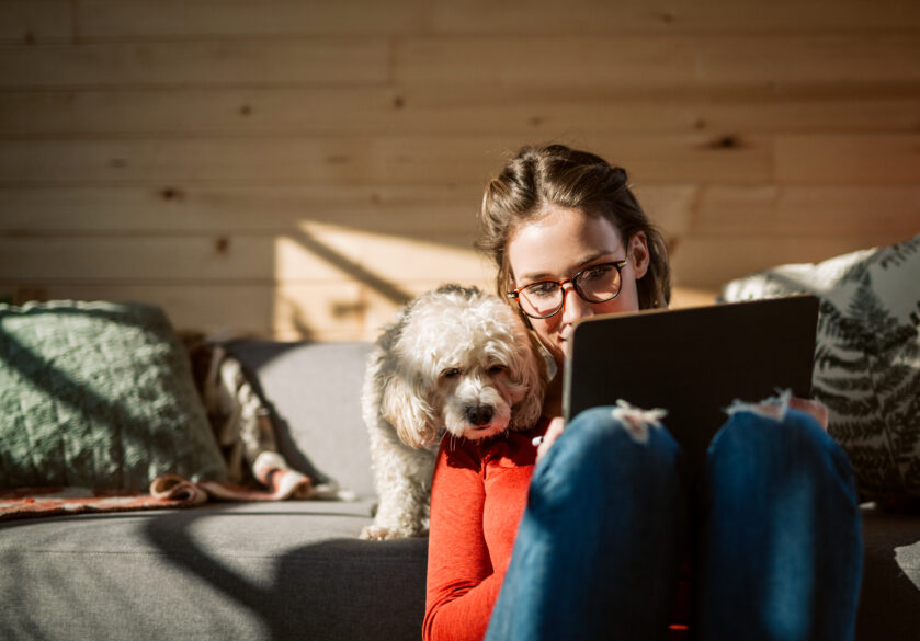 Woman with dog working on a laptop