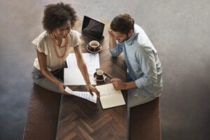 Two people discussing work at a desk
