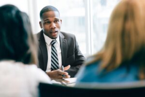 Man in suit speaking to people