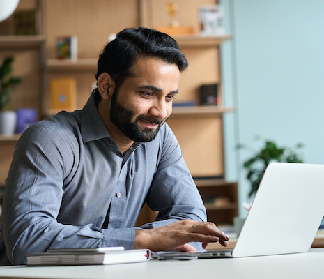 Man smiling using a laptop