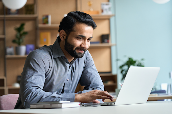 Man smiling using a laptop