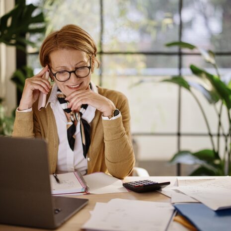 Middle aged businesswoman using laptop while working from home