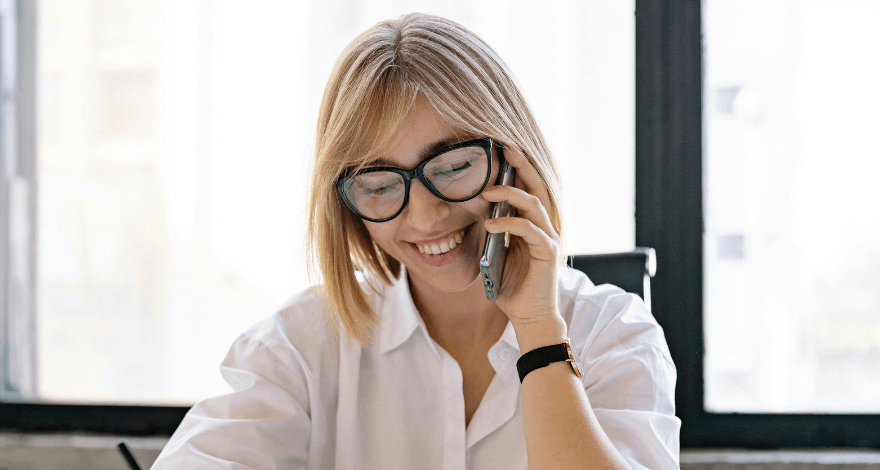 Lady dressed in corporate attire on the phone taking notes