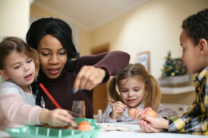 Nanny with three children prepare for Easter.