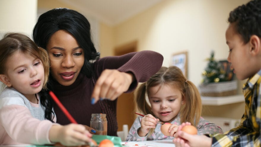 Nanny with three children prepare for Easter.