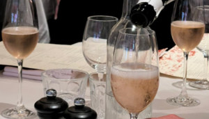 Image of four champagne flutes with a pouring bottle