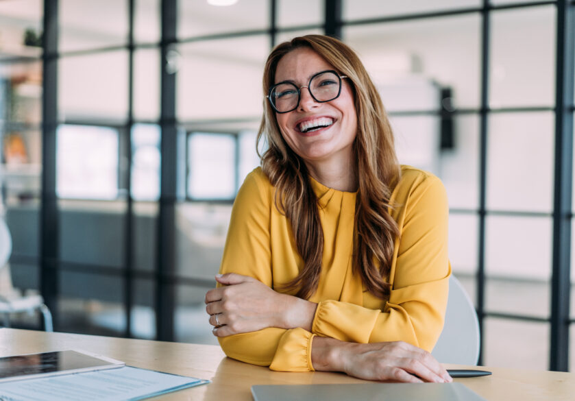 A human resources manager smiling during a meeting at a desk in a meeting room